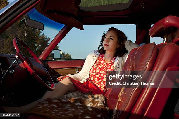 a pretty rockabilly woman sitting in the front seat of a vintage car - rockabilly pin up girls stock pictures, royalty-free photos & images