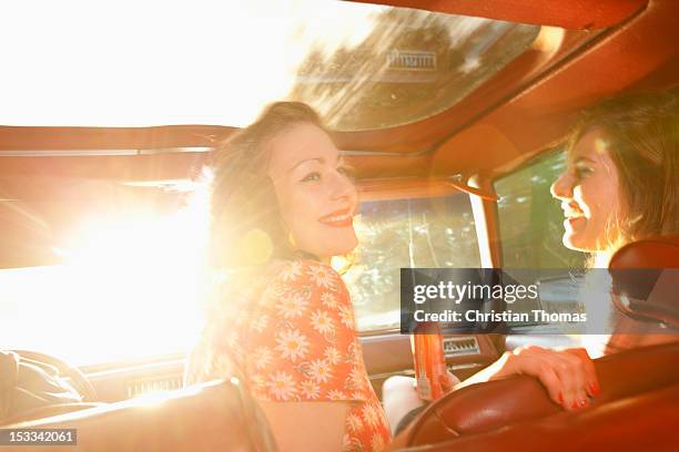 two rockabilly women having fun in the front seat of a vintage car - rockabilly pin up girls stock pictures, royalty-free photos & images