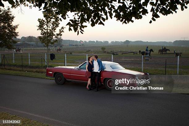a rockabilly couple leaning against a vintage car in the country - rockabilly pin up girls stock pictures, royalty-free photos & images