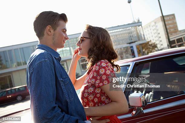 a rockabilly couple standing face to face next to a vintage car - rockabilly pin up girls stock pictures, royalty-free photos & images