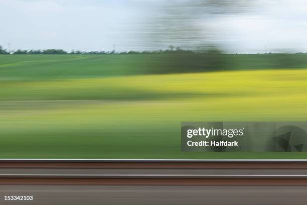 a rural landscape in blurred motion viewed from a moving train - fast train stock pictures, royalty-free photos & images