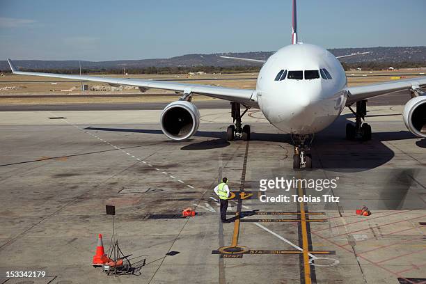 ground crew and jet on runway - sydney airport stock-fotos und bilder