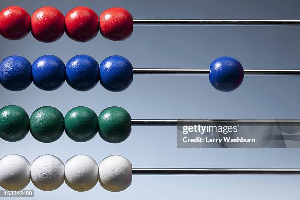 neat rows of colored beads on an abacus with a single blue bead to the side - abaco fotografías e imágenes de stock