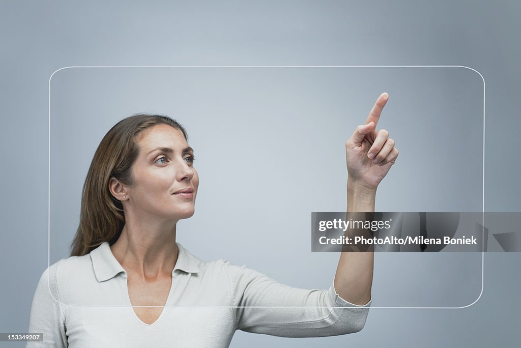 Woman using large transparent touch screen