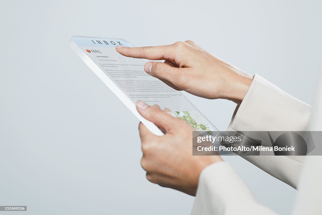 Woman checking email using futuristic digital tablet, cropped