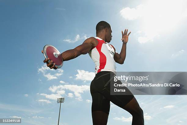 male athlete throwing discus, low angle view - lançamento do disco imagens e fotografias de stock