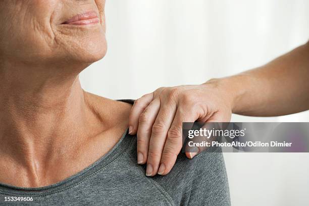 comforting hand on senior woman's shoulder, cropped - hand on shoulder stock pictures, royalty-free photos & images