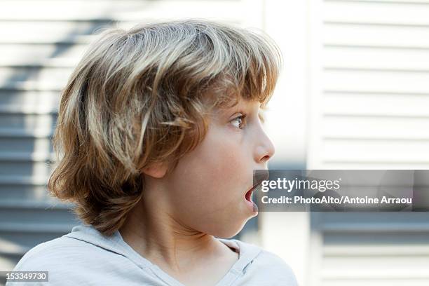 boy looking away with shocked expression - boy looking over shoulder stock pictures, royalty-free photos & images