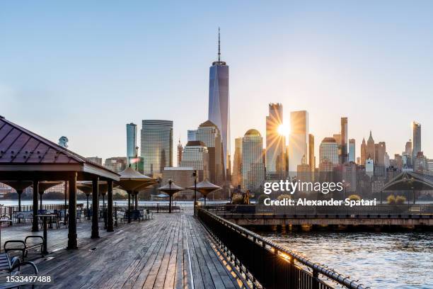 sunrise in new york city seen from the pier in jersey city, usa - jersey city stock-fotos und bilder