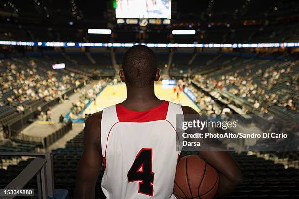 basketball player looking down at stadium, rear view - uniforme di basket foto e immagini stock