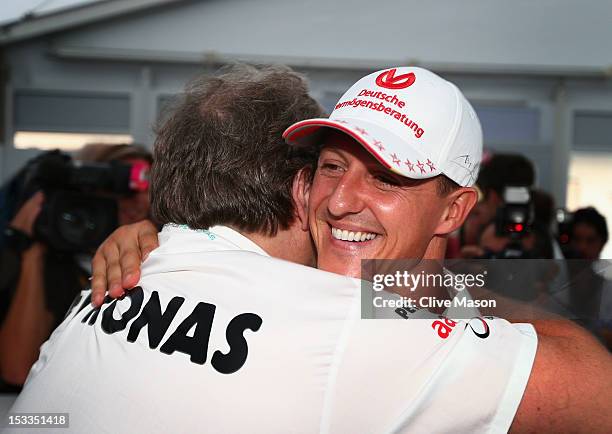 Michael Schumacher of Germany and Mercedes GP embraces Mercedes Motorsport President Norbert Haug after announcing his retirement during previews for...