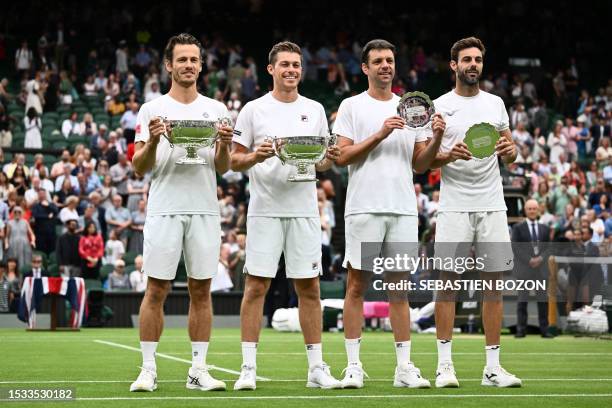 Winners, Netherlands' Wesley Koolhof and Britain's Neal Skupski hold their trophies beside runners-up Spain's Marcel Granollers and Argentina's...