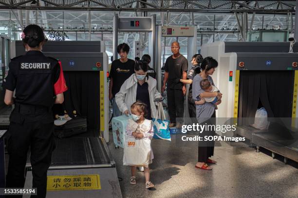 People undergo security checks at Guangzhou South Railway Station. Guangzhou South Railway Station is one of the largest and popular railway station...