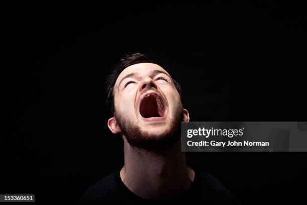 young man screaming looking up - one man only stock pictures, royalty-free photos & images