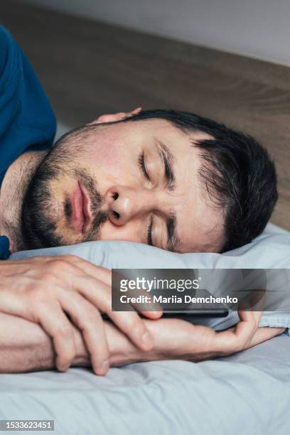 sleeping man with smartphone - overslept stockfoto's en -beelden