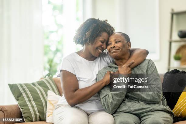 mother & daughter embrace - mother daughter adult black stock pictures, royalty-free photos & images