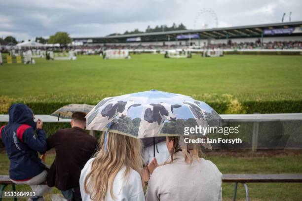 Two women shelter under an umbrella during a rain shower on the first day of the 164th Great Yorkshire Show on July 11, 2023 in Harrogate, England....