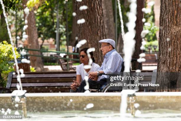 An elderly man and woman rest next to a fountain in Abelardo Sanchez Park, on 11 July, 2023 in Albacete, Castilla-La Mancha, Spain. All of Spain,...