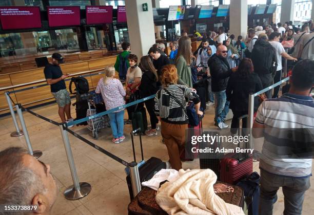 Passengers line up to check in for a flight at BER airport on July 04, 2023 in Berlin, Germany. Travelers are flocking to Europe in record numbers...