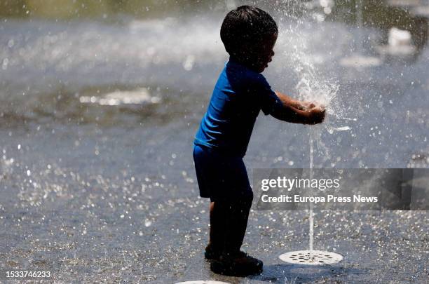 Child plays in a fountain in Madrid Rio, on 11 July, 2023 in Madrid, Spain. The Community of Madrid maintains activated from this Sunday the yellow...