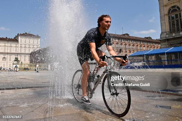 Man rides a bicycle inside a fountain in Piazza Castello on July 11, 2023 in Turin, Italy. The record for the highest temperature in European history...