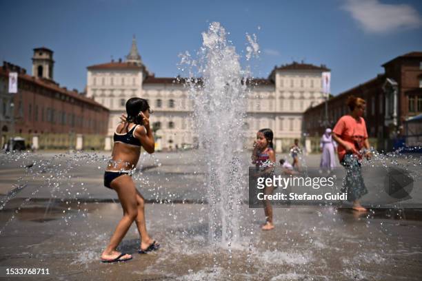 Children refresh themselves and play inside a fountain in Piazza Castello on July 11, 2023 in Turin, Italy. The record for the highest temperature in...