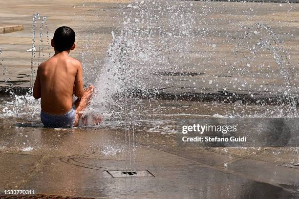 Children refresh themselves and play inside a fountain in Piazza Castello on July 11, 2023 in Turin, Italy. The record for the highest temperature in...