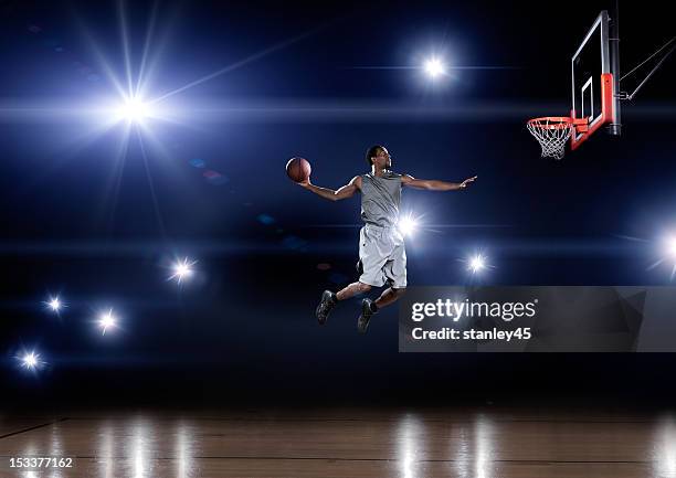 basketball player jumping toward the net - basketball dunk stock pictures, royalty-free photos & images