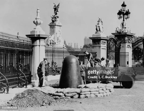 British Army Royal Engineers dig and sandbag an emplacement for a Consul armour plated one man air-raid shelter in the courtyard of Buckingham Palace...