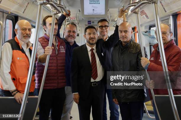 In suit and tie, Marti Batres, head of the Mexico City government, accompanied by Guillermo Calderon , Sistema de Transporte Colectivo Metro; Jesus...