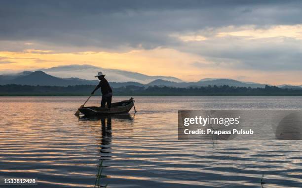 fisherman and sunrise bang phra reservoir chonburi province thailand. - deep ocean stock pictures, royalty-free photos & images