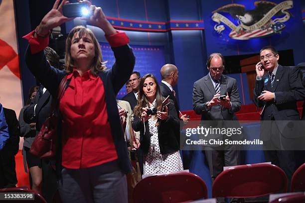 Audience members take photographs of first lady Michelle Obama's chair before the start of the first presidential debate between Democratic...