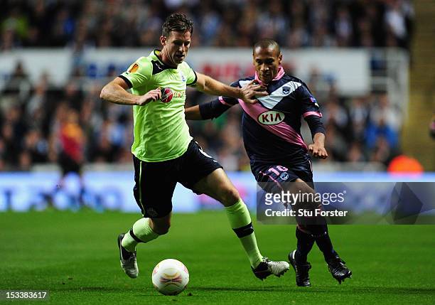 Newcastle player Mike Williamson beats Bordeaux player Jussie to the ball during the UEFA Europa League match between Newcastle United and FC...