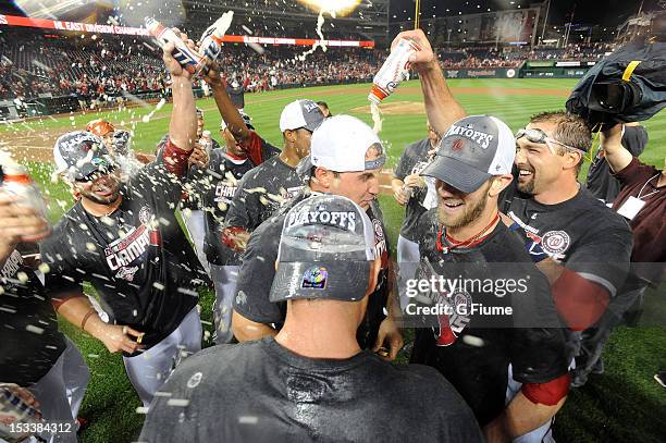 Ryan Zimmerman of the Washington Nationals is doused by teammates celebrating after winning the National League East Division Championship after the...