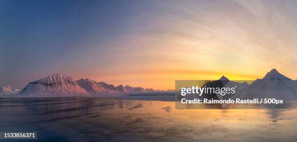 scenic view of snowcapped mountains against sky during sunset - midnight sun norway ストックフォトと画像