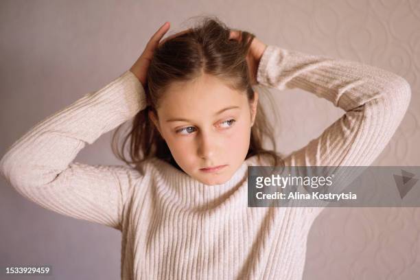 portrait of a girl doing her hair - hair growth stock pictures, royalty-free photos & images