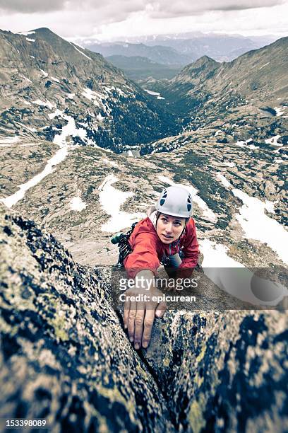 storm looming behind a female rock climber in colorado - leanincollection stock pictures, royalty-free photos & images