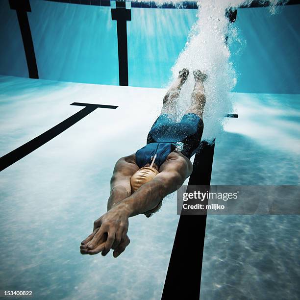 nadador buceo después del salto en piscina - diving sport fotografías e imágenes de stock