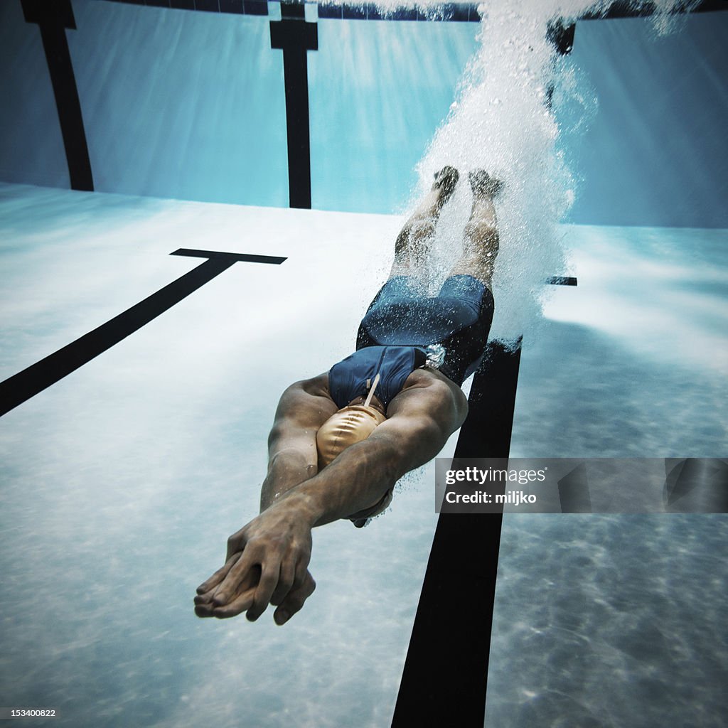 Swimmer diving after the jump in swimming pool