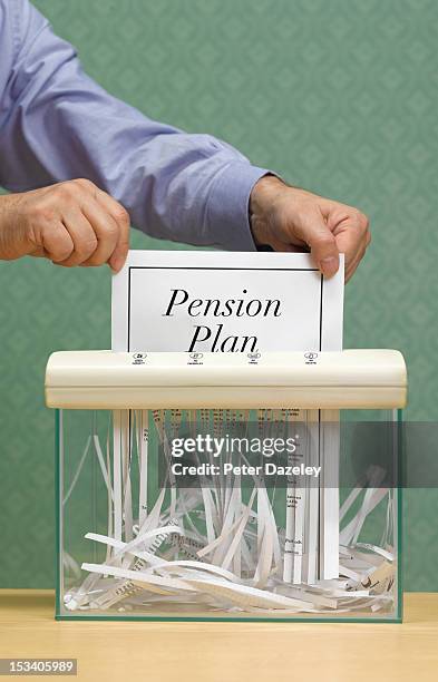 senior man shredding pension plan - pension altersvorsorge stock-fotos und bilder