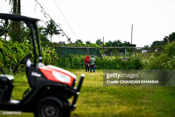 People work in a farm as it rains with high humidity during a heat wave in Homestead, Florida on July 15, 2023. Tens of millions of Americans were...