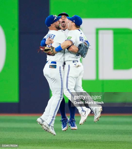 George Springer, Kevin Kiermaier, and Daulton Varsho of the Toronto Blue Jays celebrate defeating the Arizona Diamondbacks in their MLB game at the...