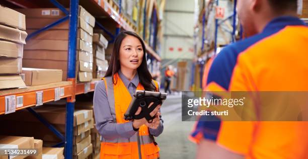 warehouse supervisor with colleague - asian females stock pictures, royalty-free photos & images