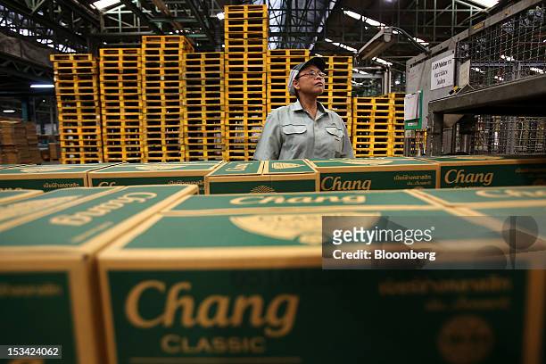 Worker inspects boxes of Thai Beverage Pcl Chang beer as they move along the production line at the company's Beer Thip brewery in Bang Ban,...