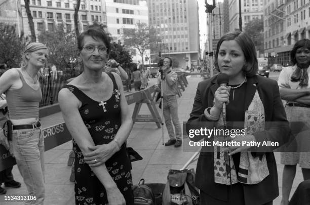 American transgender rights activist Sylvia Rivera stands beside New York City Council member Christine Quinn, who speaks into a microphone during a...