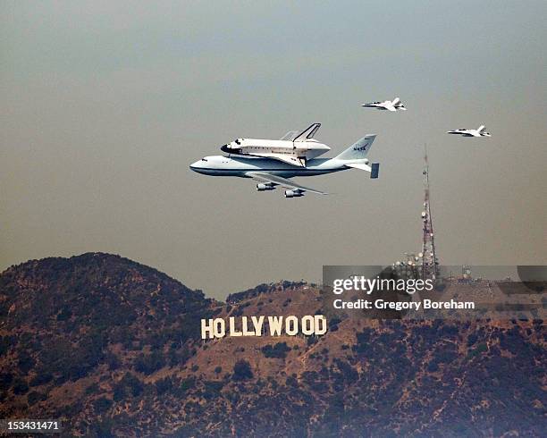 Space Shuttle Endeavour atop a NASA 747 Shuttle Carrier Aircraft passes over the Hollywood sign during its last farewell flight.