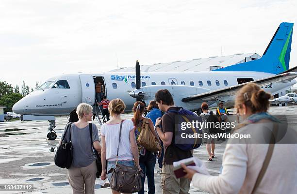 Passengers and tourists are walking on the airfield to an aircraft of the domestic and regional airline Sky Bahamas at Lynden Pindling International...