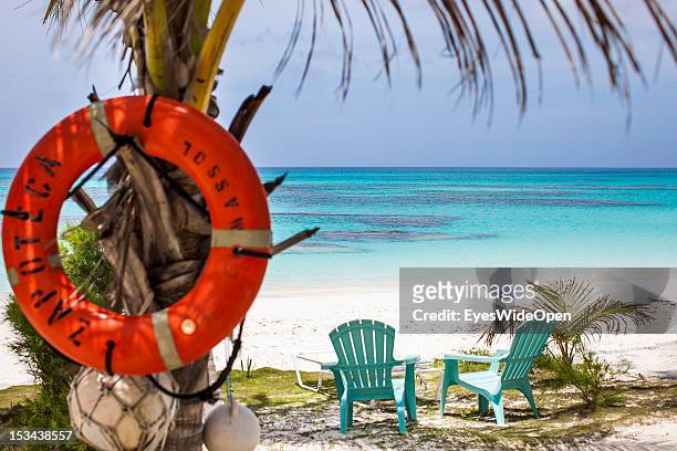 Life belt, lifesaver, is hanging on a palmtree at the white and sandy 8-Miles-Beach with two chairs overlooking the turquois blue waters of the...