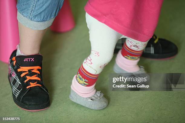 Volunteer plays with 11-month-old Lucy in the playroom of the "Jule" facility for single parents as her mother Nancy Kett looks on in...