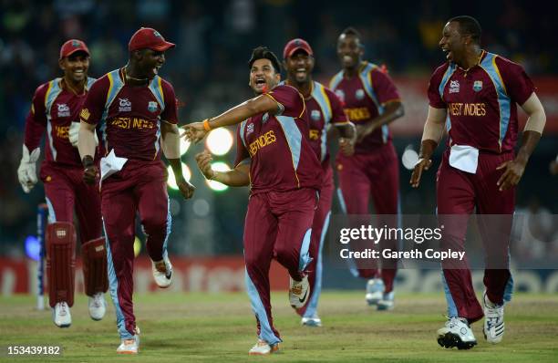 Ravi Rampaul of the West Indies celebrates with Darren Sammy and Kieron Pollard after dismissing David Hussey of Australia during the ICC World...